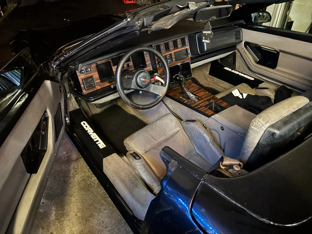 Interior of a 1980s Chevrolet Corvette convertible with tan leather seats before deep cleaning