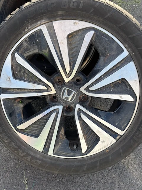 Dirty Honda alloy wheel coated in brake dust and road grime before wheel and tire cleaning