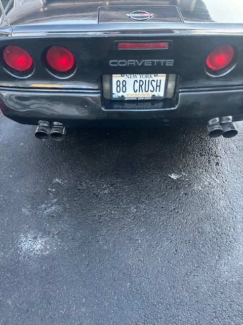 Rear end of a black C4 Chevrolet Corvette with clean tail lights and polished bumper