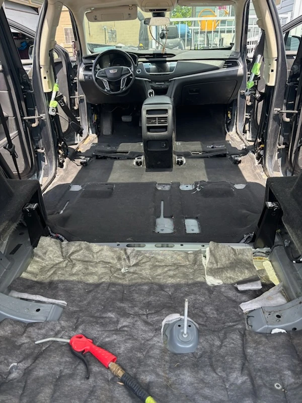 Cadillac XT5 with rear seats removed and carpet exposed during a deep interior extraction