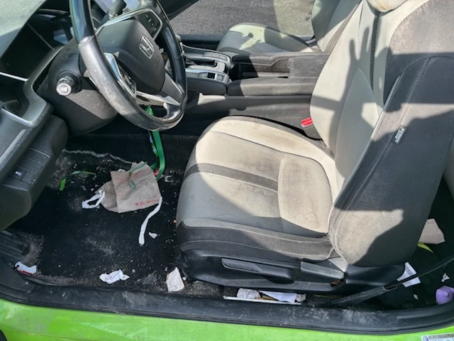 Honda Civic driver seat and floor with trash, dirt and stains before an interior deep clean